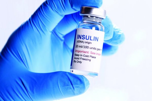 Hand holding insulin bottle